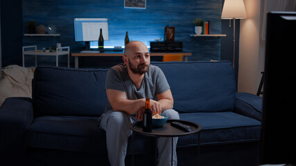 Scared shocked astonished man looking at horror movie at tv, eating popcorn trembled with fright...