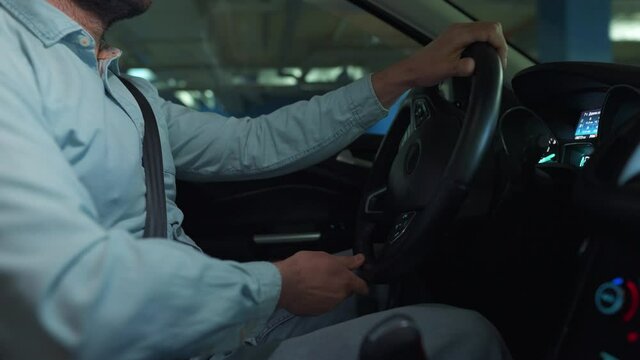 Man driving in innovative automated car using self-parking autopilot for parking on parking lot