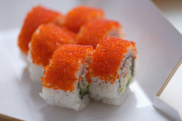Roll California with cream cheese tobiko caviar closeup.