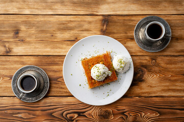 Turkish dessert kunefe served with ice cream on wooden background