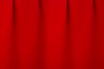 Saturated scarlet red silk curtain with smooth creases as luxury classic theatre abstract background.