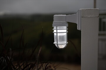 White lamp mounted on a fence post. electrical equipment for illumination decorative