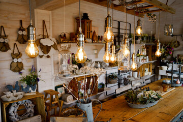 Beautiful arrangement of wooden decor and ceramic decoration in a shop for indoor, outdoor and garden. Light bulb as fairy lights.