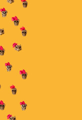 human skull with a pink bow against yellow illuminating background with copy space. abstract helloween art. helloween. holliday. mortal. skull.