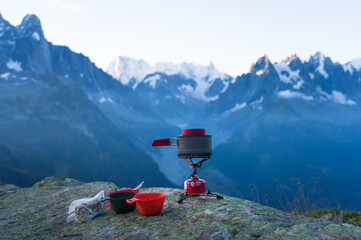 A gas stove with a pan of boiling water for a breakfast in the mountains near Chamonix.