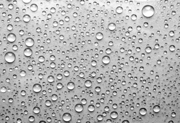 Water drops on glass. Grey background with raindrops on glass