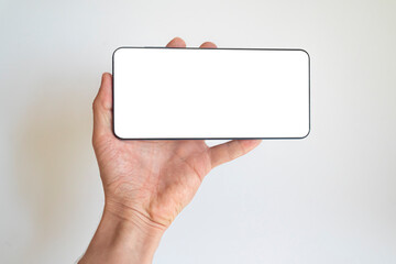 Woman hand holding smartphone with white screen, on white background. Empty white space to write...