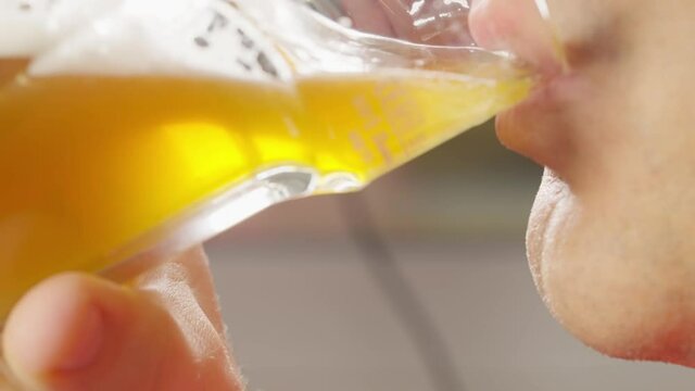 Close up on the mouth of a man drinking a glass of beer