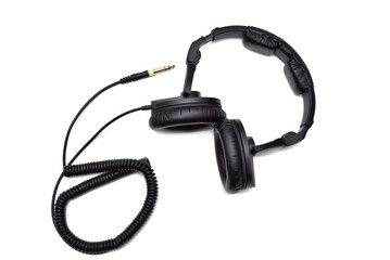 Top view of black wired stereo headphones with audio jack on white background.