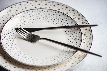 Two porcelain Christmas plates with snowflake borders and cutlery