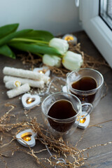two cups of coffee on valentine's day with sweets and tulip flowers