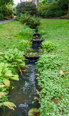 Fototapeta na wymiar a stream running through estate gardens in the grade I listed gardens at Bodnant Gardens, Colwyn Bay, Wales UK