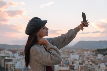 young woman makes a self portrait with her mobile outdoors