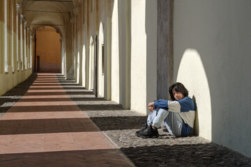Fototapeta na wymiar Teenage girl sitting on the street of the Italian old town
