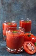 Tomato juice in glasses. Blue vintage background. Rustic.