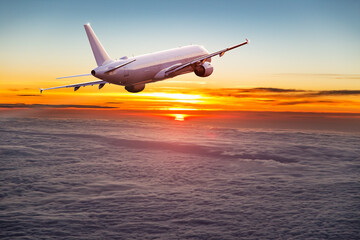 Fototapeta na wymiar Commercial airplane flying above dramatic clouds.