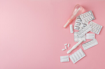 vaginal suppositories, enema, tablets, applicator sanitary napkin on pink background, treatment of vaginal infections with smile from candidiasis, thrush, sexually transmitted infections. Woman health