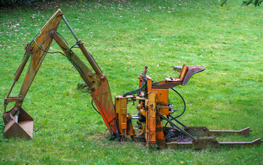 seated digger abandoned in grass field Betws-y-coed, Snowdonia Wales UK