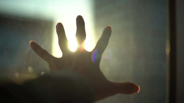 光に手を差し出す男性