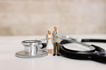 Miniature people near a stethoscope. Concept of insurance and health