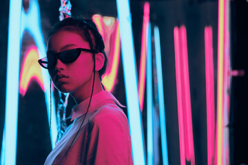 Teenage asian girl in sun glasses in neon light