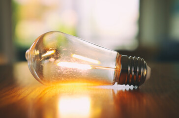 Close up of light bulb on wooden table. energy concept or invention