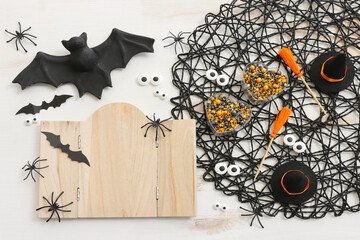 holidays image of Halloween. witch hat, broom, spiders, bats and wooden board frame for text or mock up over white table