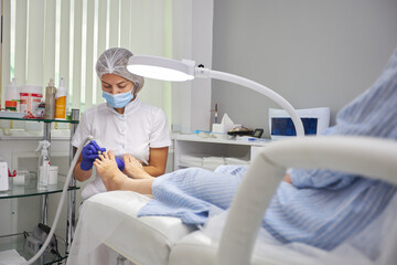 Woman in pedicure salon getting her feet peeled