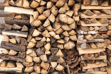 Birch and aspen firewood stacked in a woodpile. Autumn in Siberia. Preparing for winter.
