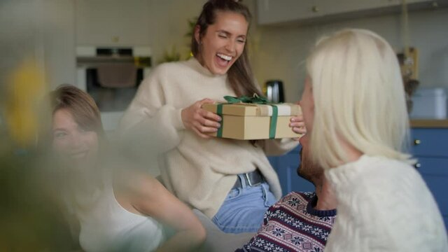 Woman receiving sweater as Christmas present. Shot with RED helium camera in 8K 