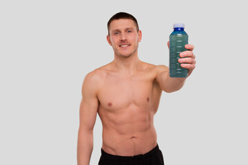 Fototapeta premium Sportman Holding Sport Drink. Energy Drink for Sport. Topless man with Drink in Hands.