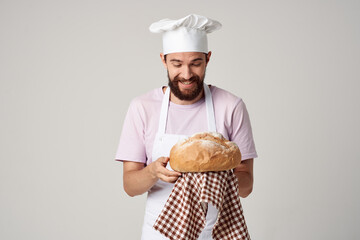 a man in a chef's uniform holding bread in his hands kitchen Professional industry