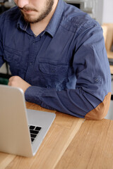 Man using laptop at wooden table