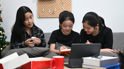 Asian girls having online lesson at home together.