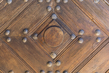 Old wooden doors, elements connected with metal rivets, close-up, wood texture