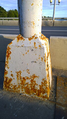 Lantern post metal corrosion. City road. Rust steel construction. Rusty messy surface. Damaged grunge texture from road salt. Protecting and paint work concept. Stained. Materials for Outdoor Lighting