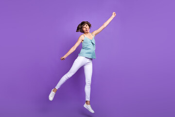 Obraz premium Full length body size view of lovely cheerful girl jumping holding copy space isolated over bright violet purple color background