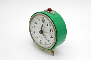 Vintage metal green alarm clock, isolated on white background, close-up