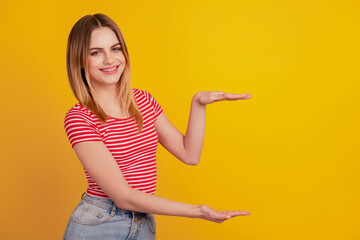 Profile side photo of young girl show hands measure metaphor size isolated over yellow color background