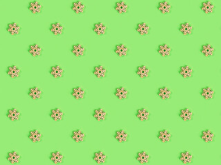 Beautiful pattern of the handmade wooden snowflake on the green background.
