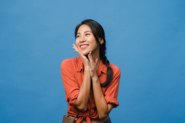Portrait of young Asia lady with positive expression, smile broadly, dressed in casual clothing over blue background. Happy adorable glad woman rejoices success. Facial expression concept.