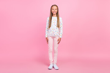 Photo of cheerful positive candid little lady look camera wear dotted shirt pants shoes isolated pink color background