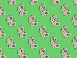 Obraz premium Beautiful pattern of the handmade wooden knitted gloves on the green background.