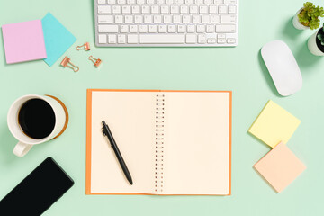 Creative flat lay photo of workspace desk. Top view office desk with keyboard, mouse and open mockup black notebook on pastel green color background. Top view mock up with copy space photography.