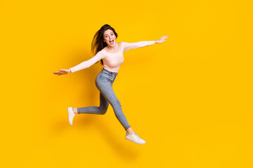 Fototapeta na wymiar Full size photo of young happy excited smiling girl flying hold hands wings isolated on yellow color background