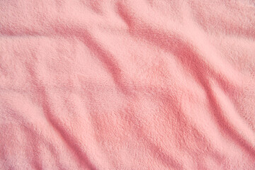 Fototapeta na wymiar Fluffy gentle pastel pink fabric with waves and folds. Soft pastel textile texture.