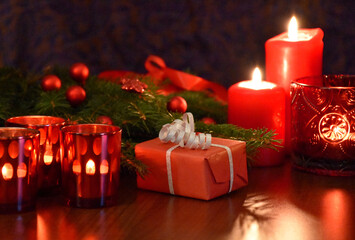 Christmas red gift box with spruce branch and burning candles stock images. Beautiful christmas decorations still life on the table photo images