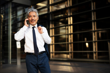 Senior businessman outdoors. Middle-aged businessman talking to the phone