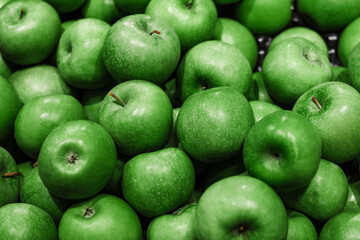 rich green apples are piled on top of each other in a mess