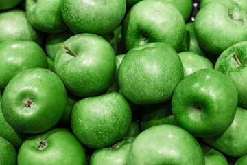 rich green apples are piled on top of each other in a mess